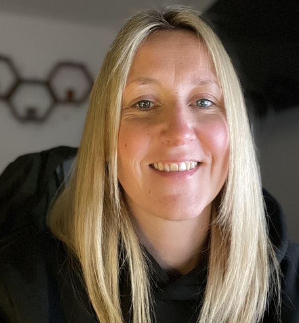 A lady with long blonde hair smiling at the camera