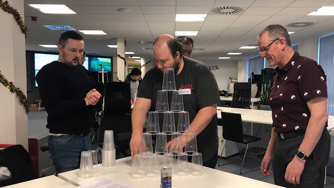 Team members doing cup team building challenge